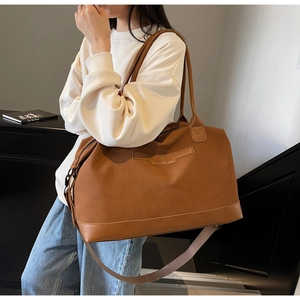 Detail of matte brown large capacity tote bag with NING JIA logo and adjustable strap