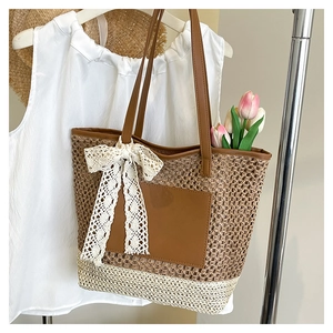 Détail d'un sac cabas tressé avec poche en cuir marron et nœud en dentelle blanche