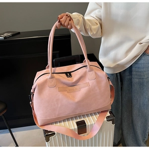 Détail du grand sac cabas rose avec logo en cuir et bandoulière réglable pour le voyage