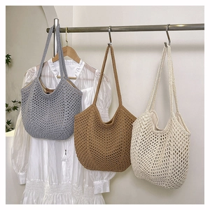 Detailed side view of large woven tote bags in grey brown and beige displayed on a rack