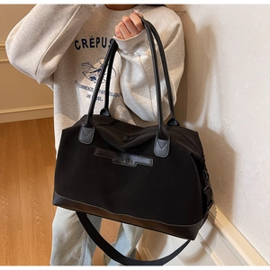 Vue détaillée du grand sac cabas noir en nylon avec poignées en cuir et logo