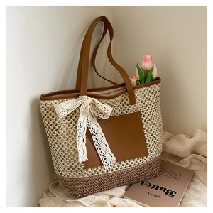 Détail du sac cabas tissé avec poche en cuir contrastée et grand nœud en dentelle blanche