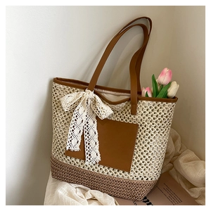 Détail du sac cabas tissé avec bandoulière en similicuir marron et nœud en dentelle blanche