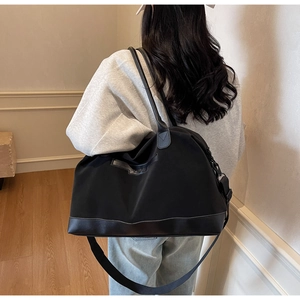 Détail du grand sac cabas noir avec sangles renforcées et tissu résistant à l'eau