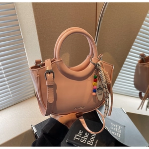 Pink PU leather bucket bag detail with beaded charms and circular top handles