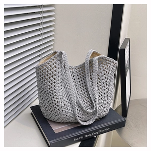 Detail of the gray crochet weave texture and white fabric lining on the stylish tote bag