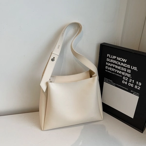 Detailed view of cream leather tote bag with silver adjustable buckle on wide shoulder strap