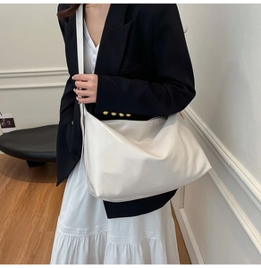 Minimalist white high-gloss hobo bag shown with a black blazer for a professional look