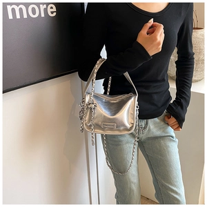 Detail of silver metallic handbag with Fashion label and chain strap worn by a model