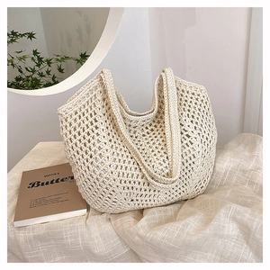 Detail of hand-woven cream crochet tote bag with openwork mesh and dual shoulder straps