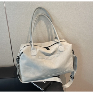 Close-up of minimalist large tote bag with brand logo and soft faux leather texture