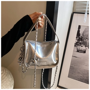 Detail of silver metallic crossbody bag with chain strap and fashion metal logo plate
