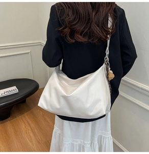 Detail of a large cream hobo tote bag with a wide shoulder strap and decorative scarf