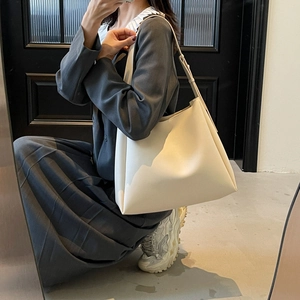 Side view of creamy white oversized tote bag on model for casual everyday style