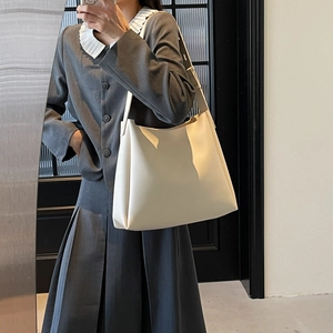 Close-up of a minimalist cream-colored large capacity shoulder bag for daily commuting