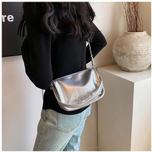 Detail of silver metallic handbag featuring wrinkled texture and elegant chain strap