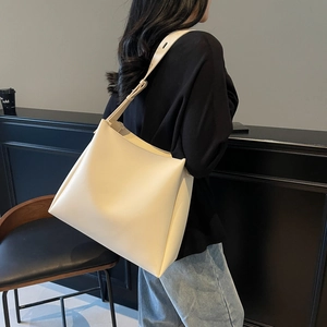 Detail of adjustable strap on cream large capacity tote bag shown on shoulder