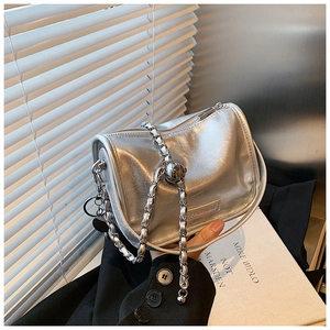 Detail of silver crossbody bag with pleated texture, chain strap, and fashion plate