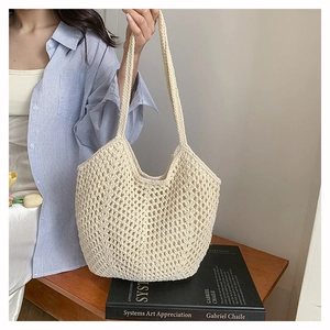 Detailed macro view of cream crochet shoulder bag texture on an art book surface