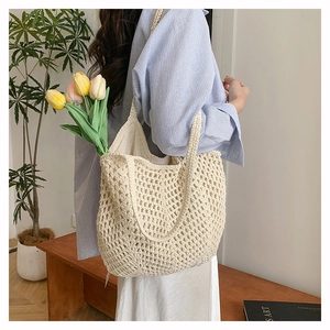 Macro view of hand-woven beige tote bag with hollow diamond pattern and cotton mesh texture