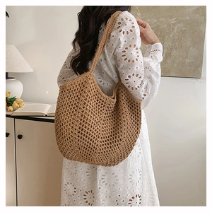 Detail shot of a large brown hand-woven straw tote bag with a hollow-out mesh design