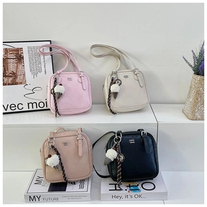 Detail of four colorful square shoulder bags with soft fur ball ice cream charms