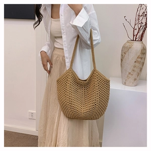 Close-up of large woven straw shoulder bag with hollow-out pattern for beach vacation