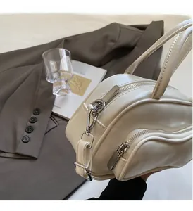 Detailed close-up of premium cream leather texture and shiny silver hardware on handbag