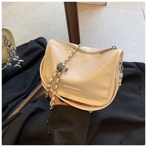Detailed view of off-white glossy leather handbag with silver chain and Fashion label