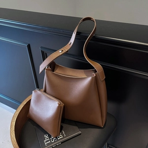 Detail of vintage dark brown faux leather bucket bag set with adjustable shoulder strap