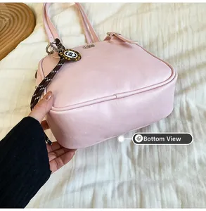 Close-up of the baby pink shoulder bag showing the structured bottom and thickness