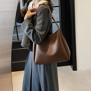 Detail of dark brown leather tote bag showing soft matte texture and spacious slouchy design