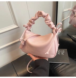 Detail of pink faux leather bag with ruched handle and Fashion & Bags text logo