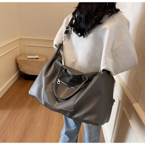 Vue détaillée du grand sac de voyage gris foncé avec poignées renforcées et cuir souple