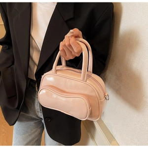 Détail du mini sac en cuir verni rose avec poche zippée ondulée et boucles en métal