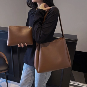 Brown leather tote bag set with a matching small pouch worn on the shoulder