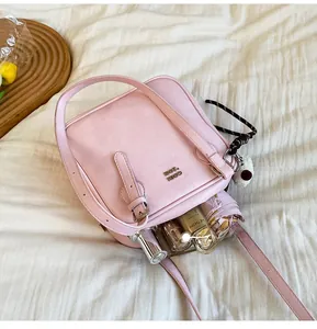 Detail view of the interior capacity of a pink square shoulder bag with cosmetics