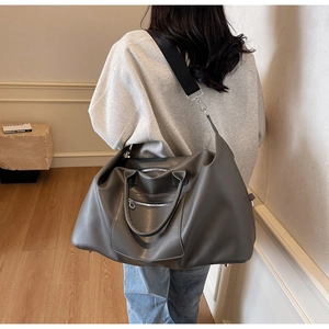 Détail du sac de voyage gris foncé avec bandoulière réglable et doubles zips frontaux
