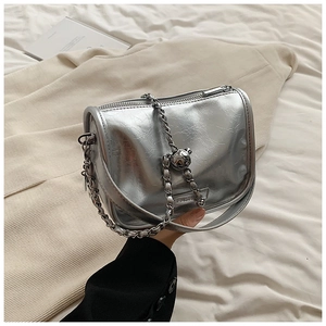 Detail of silver metallic handbag with polished chain strap and round ball charm ornament