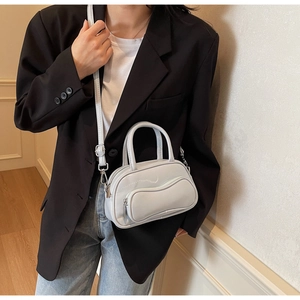 Détail d'un sac Boston gris avec poches ondulées et une fine bandoulière réglable