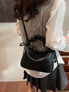 Fashionable black faux leather shoulder bag with ruched handles and a cloud-shaped design