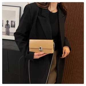 Chic camel chain crossbody bag shown on a black blazer for a stylish urban commute look