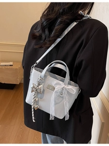 Light blue patent leather bucket bag with silver bow charm and lace decoration