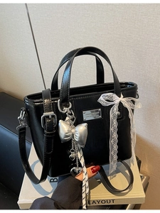 Glossy black bucket bag with white lace bow and silver heart pendant charm