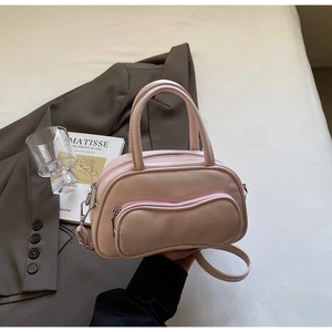 Detail view of pink Boston bag showing smooth PU leather texture and curved zipper pockets