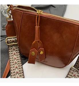 Λεπτομέρεια καφέ vintage τσάντας κουβά με ομαλό φερμουάρ και υφαντό γεωμετρικό ιμάντα