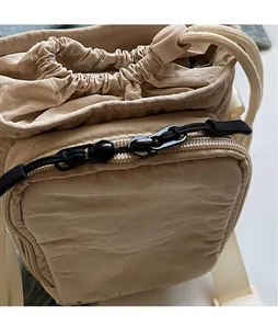 Detail der Mini-Stofftasche mit Kordelzugverschluss und glatten Metallreißverschlüssen