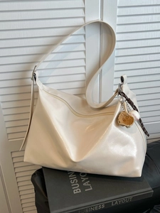 Creamy white high-capacity tote bag with glossy leather finish and baseball charm