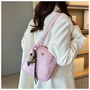 Detail of pink PU leather underarm bag with metal logo and ice cream charm