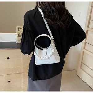 Detail of beaded handle shoulder bag in light grey leather on female model's back